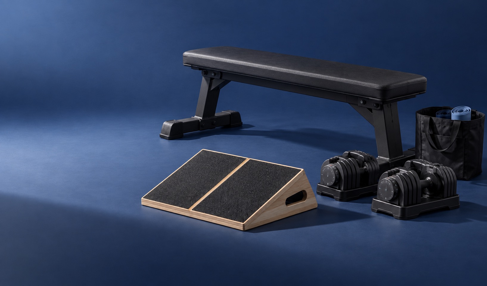 A prepared home training space with a slant board and adjustable dumbbells